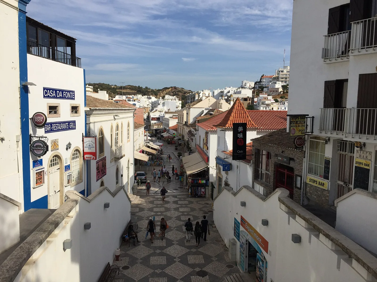Photo: ianpudsey, CC BY 3.0, via Wikimedia Commons Lively street with white houses in Albufeira Old Town