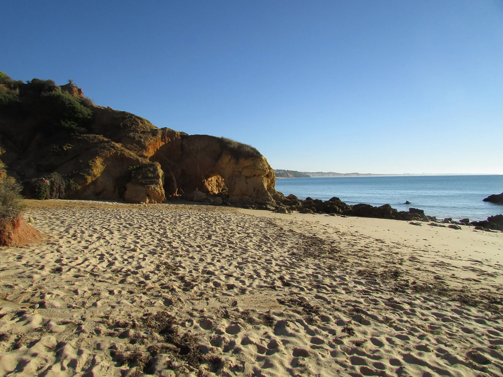 Photo: Kolforn, CC BY-SA 4.0, via Wikimedia Commons Golden rocks and calm sea at Praia de Santa Eulália, Albufeira