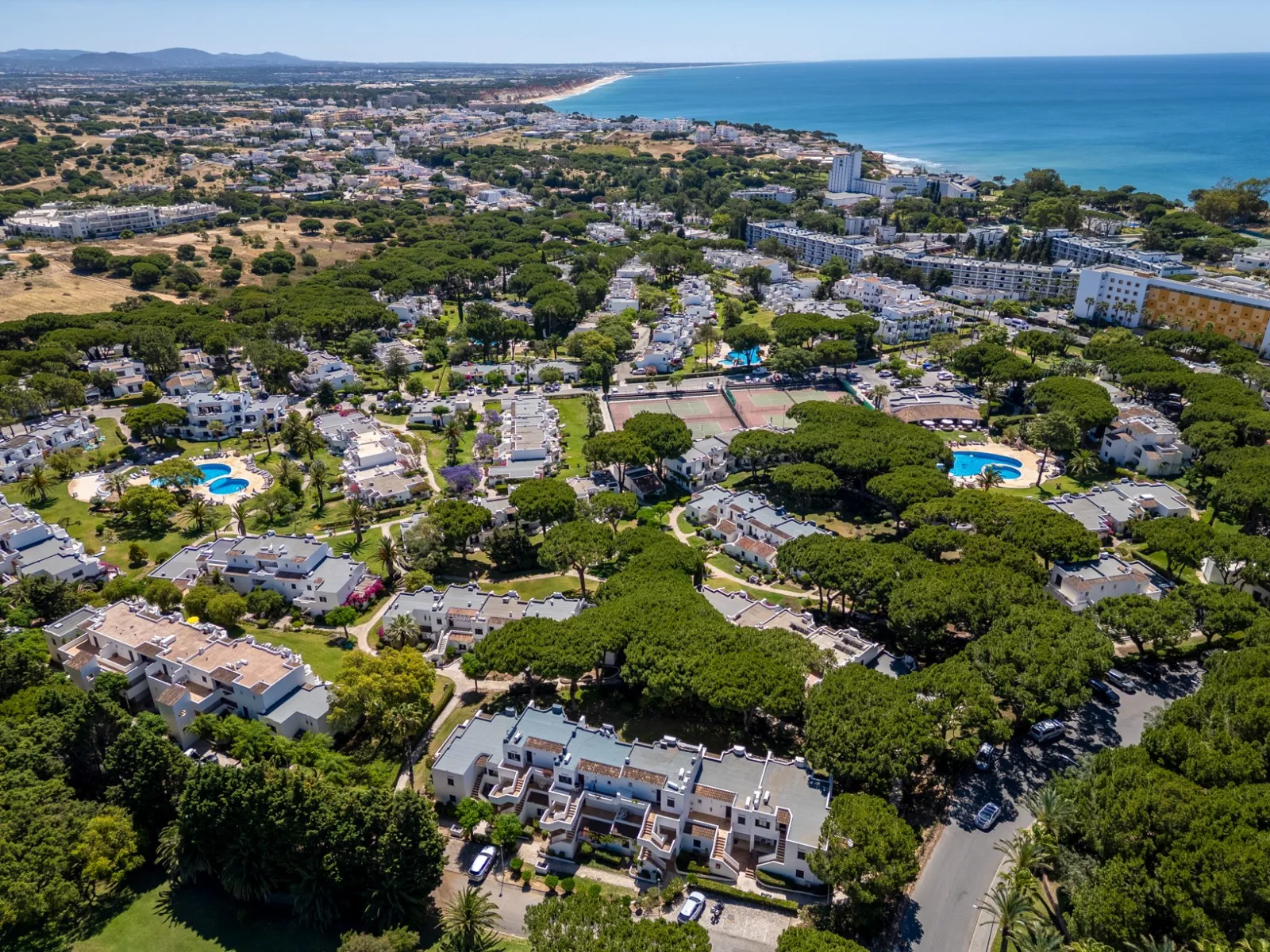 Aerial view of Balaia Golf Village pools, tennis courts and the coast